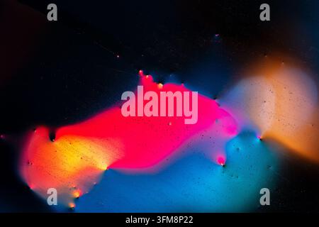 Abstract colorful fluid light spreading across a dark background, forming vibrant cosmic patterns and glowing textures Stock Photo