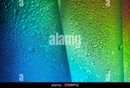 Water droplets adhering to a textured plastic film, forming an abstract background with a vibrant blue to green color gradient Stock Photo