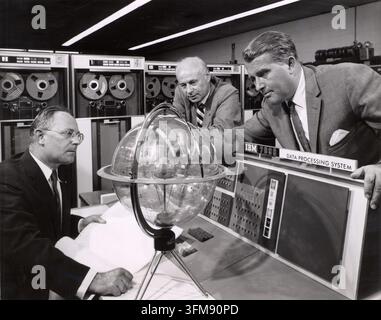 A photograph depicting Wernher von Braun (1912–1977), Dr Helmut Hoelzer (1912–1996), and Dr Eberhard Rees (1908–1998) at the Marshall Space Flight Centre. Von Braun, the German-born aerospace engineer and pioneer of the United States space programme, is shown leaning over an IBM 7090 Data Processing System console in discussion with his colleagues. As the first Director of the Marshall Space Flight Centre, Von Braun led the development of the Saturn V rocket that eventually propelled the Apollo missions to the Moon. 1960. Stock Photo