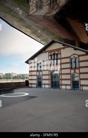 Architectural detail shows the historic former Podgórze power station beneath the towering contemporary Cricoteka structure. Stock Photo