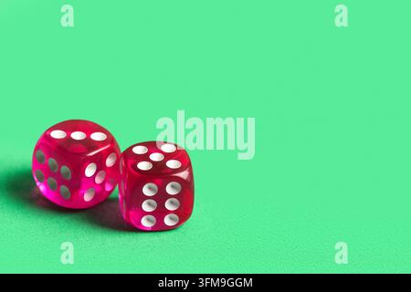 Risk and probability concept, two red translucent dice on a green background for gambling and decision making strategy in business and finance Stock Photo