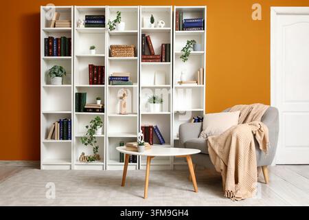 Home library and reading nook, cozy living room interior with bookshelves and comfortable armchair for relaxation and quiet study in a modern house Stock Photo