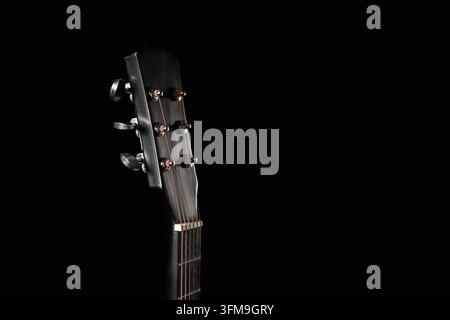 Music and creativity concept, acoustic guitar headstock with tuning pegs and strings on a dark background for artistic performance and entertainment Stock Photo