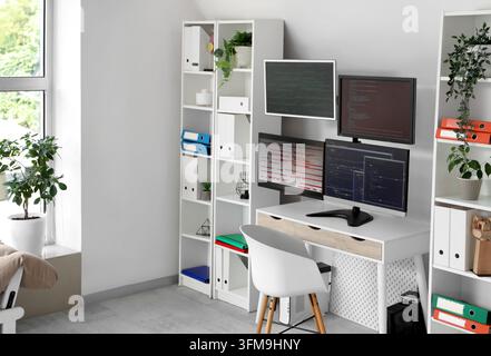 Software development and remote work, programmer home office with multiple computer monitors displaying code and data analytics in a modern workspace Stock Photo