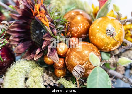 Autumn baubles with dried sunflowers in festive arrangement, glossy amber and gold tones, natural textures, balanced composition, warm atmosphere, blu Stock Photo