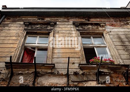 Crumbling plaster and exposed brickwork on a weathered historic tenement in Kazimierz. Stock Photo