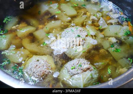 Stuffed cabbage parcels with minced pork and glass noodles in clear soup with wax gourd in a stainless steel pot in Thailand, no people Stock Photo