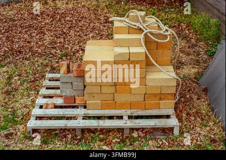 Stacked Bricks and Construction Materials on Wooden Pallet Stock Photo