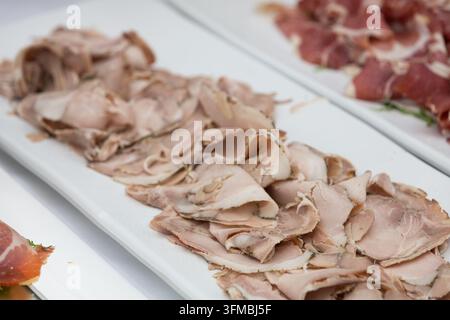 Platter presenting various thinly sliced cold cuts and cured meats at a buffet Stock Photo