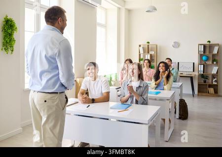 Teacher engaging students in bright classroom during university lecture session Stock Photo