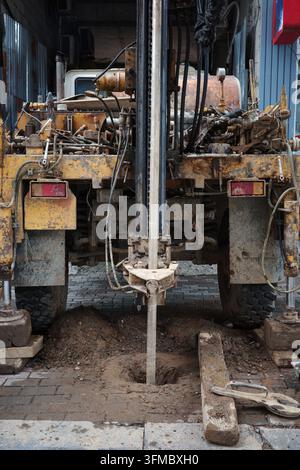 Geotechnical drilling rig borehole construction soil investigation hydraulic machinery working on urban ground for foundation testing and engineering.. Stock Photo