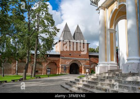 A tranquil scene of a historic fortress gate, featuring sturdy brick walls, pointed towers, and an arched walkway leading up to the entrance. The Stock Photo
