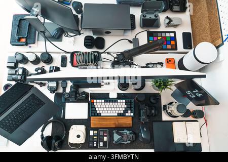 photographer desk camera equipment drone memory cards setup. Overhead top view of a content creator workspace featuring digital cameras, lenses, quadc Stock Photo