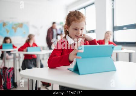 Schoolchildren using tablets and artificial intelligence tools for learning in classroom. Stock Photo