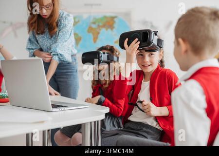 Primary school students exploring virtual reality during technology class. Stock Photo