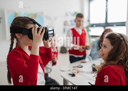 Primary school students exploring virtual reality during technology class. Stock Photo