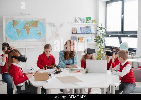 Primary school students exploring virtual reality during technology class. Stock Photo