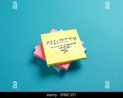 Stack of colorful sticky notes with PRIORITY message, symbolizing urgent tasks, important reminders, and time management Stock Photo