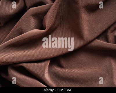 Brown fabric texture background with elegant wavy folds and detailed textile material close up Stock Photo