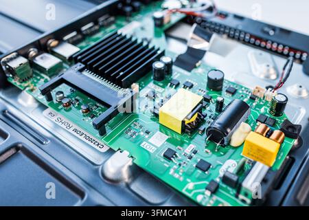 Green circuit board showing various electronic components inside a device Stock Photo