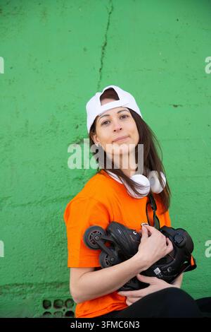Young woman with inline skates and headphones posing Stock Photo
