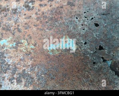 Heavily rusted old metal surface with holes and peeling paint Stock Photo