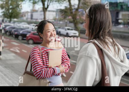 Two young women enjoying friendly city conversation Stock Photo