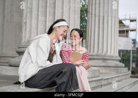 Diverse students laughing sharing moment on campus Stock Photo