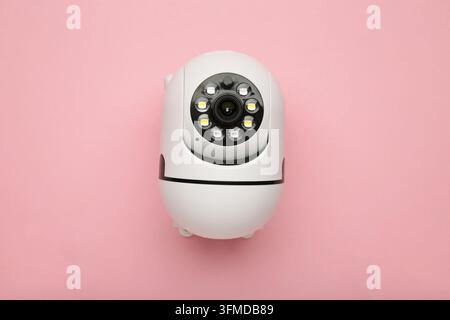 Security camera on pink background. Outdoor surveillance camera. Top view Stock Photo