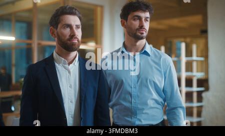 Two pensive Caucasian business men look away thinking looking for solution decision serious confident businessmen startup colleagues professionals Stock Photo