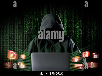 Anonymous hooded hacker using laptop with digital code and cryptocurrency security icons Stock Photo