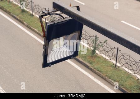 Outdoor LED floodlight reflector mounted on metal pole for street light and area illumination. Stock Photo