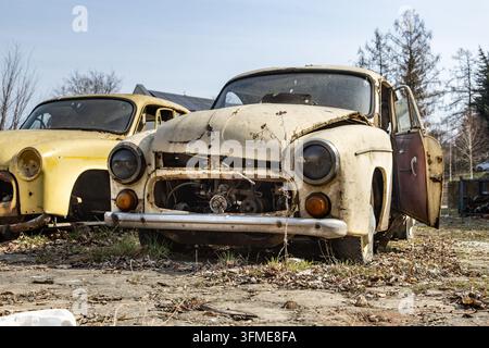 Front view of a weathered vintage car with another old vehicle behind it Stock Photo