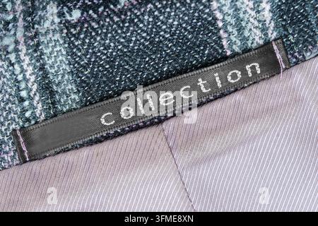 Clothes label text collection stitched on tweed and silk fabric background Stock Photo