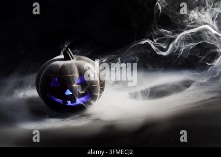 Halloween jack-o'-lantern glowing purple with mystic smoke Stock Photo
