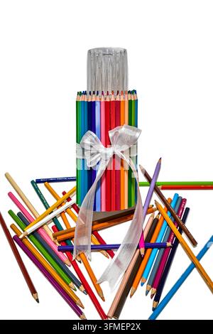 Bundle of colored pencils decorated with a white ribbon and scattered pencils in the foreground on a white background, creativity concept. Stock Photo