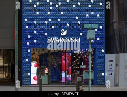 Tokyo, ginza - jan 08 2024: Swarovski Ginza store featuring a striking blue facade with glowing geometric patterns and a prominent swan logo, attracti Stock Photo
