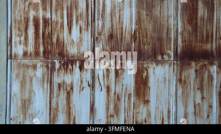 Texture of old, rusty metal with streaks and scratches. Background of vertical iron panels showing heavy corrosion and peeling paint. Grunge design Stock Photo