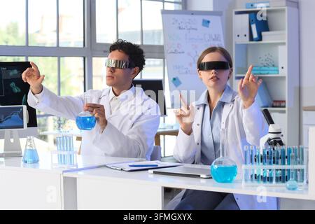 Future of science and biotechnology, researchers using augmented reality glasses for data analysis in a modern laboratory with chemical glassware Stock Photo
