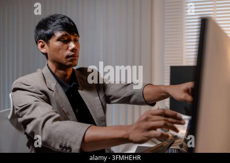 Professional trader analyzing stock market charts across multiple screens using laptop and tablet to monitor price movements, technical indicators and Stock Photo