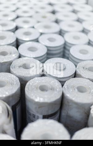 Close-up view shows numerous white rolled materials arranged in rows, with shallow depth of field. Stock Photo