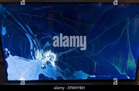 A modern television display shows severe physical damage and cracks Stock Photo