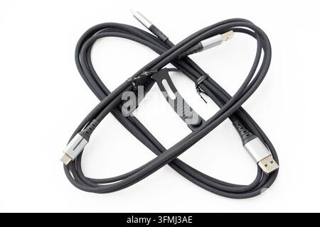Black braided cables are coiled together on a white background Stock Photo