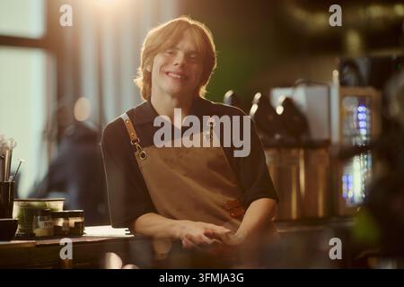 Portrait of Smiling Male Barista Standing Behind Counter in Cafe Stock Photo