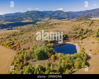 Aerial view of the Gudronove jamy acid tar lagoons surrounded by autumn trees and rolling hills of the Low Tatras mountain range in Predajna, Banskoby Stock Photo