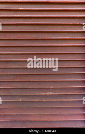 A close up shot of brown horizontal wooden louvers creating a textured surface pattern Stock Photo