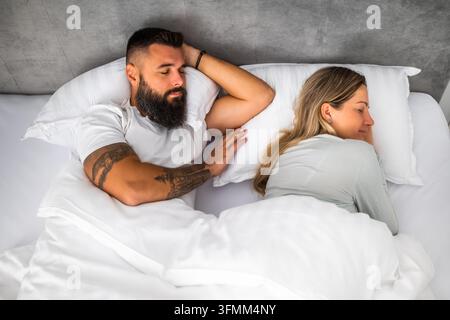 Young married couple is sleeping in their bed. Stock Photo