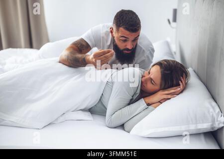 Adult couple is lying in bed and arguing. Stock Photo