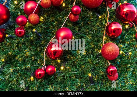 Festive background of a Christmas tree decorated with shiny red baubles Stock Photo