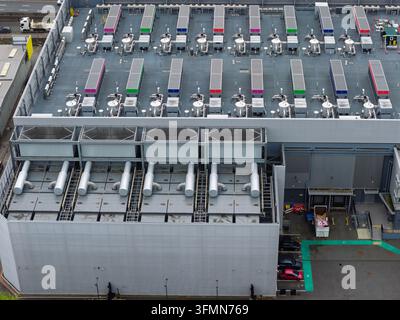 Aerial view of a large data center with rows of industrial cooling units and HVAC systems on the rooftop in the United Kingdom. Stock Photo